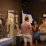 Two people converse in a museum gallery space.