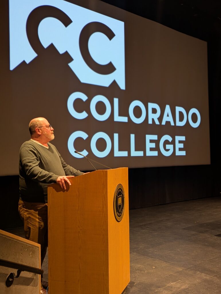 Matt Mayberry stands at a podium at Colorado College