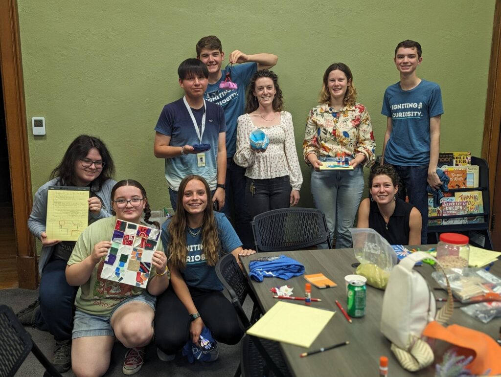 A group of high school and college students pose for a photo in the museum's family space.
