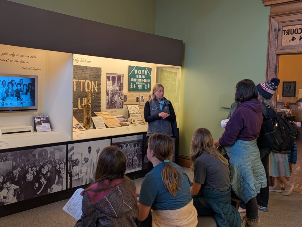 Tanja Britton, CSPM Education Volunteer, shares information in the "Any Place North & West "exhibit.