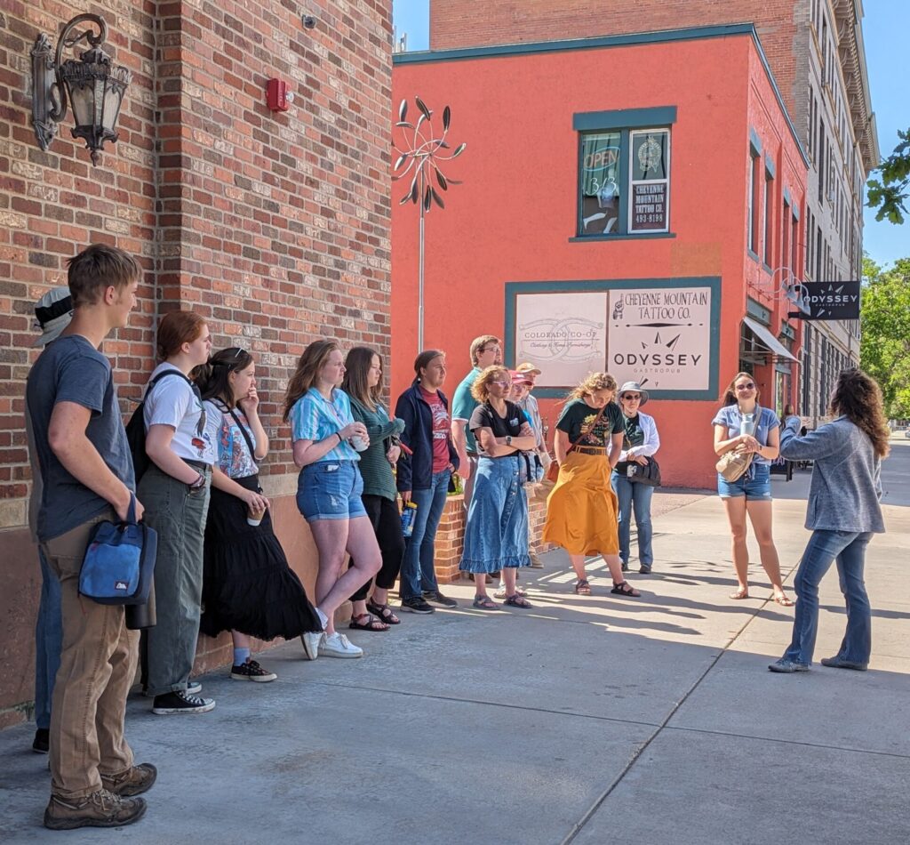 Museum staff member shares information to a large group on an outdoor walking tour.