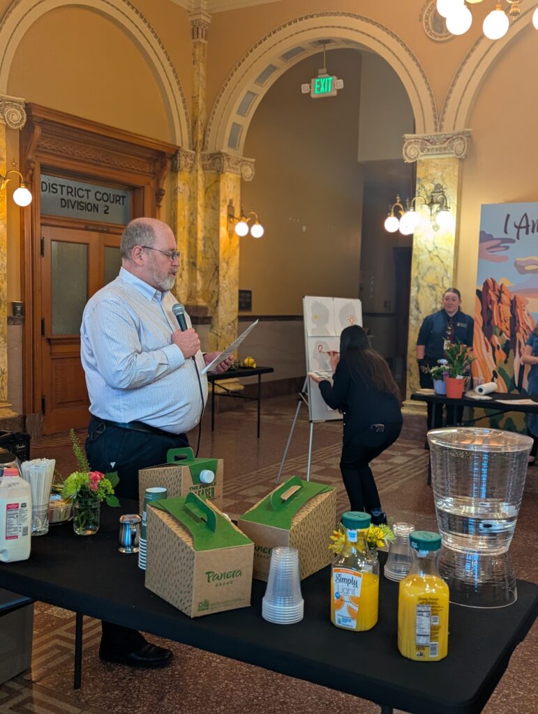 Matt Mayberry presents the Volunteer of the Year award while Valerie Schmitz paints,