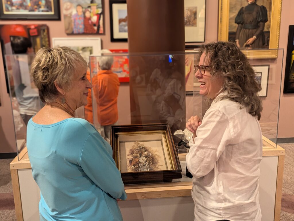 Two volunteers talking in the 50% of the Story exhibit.