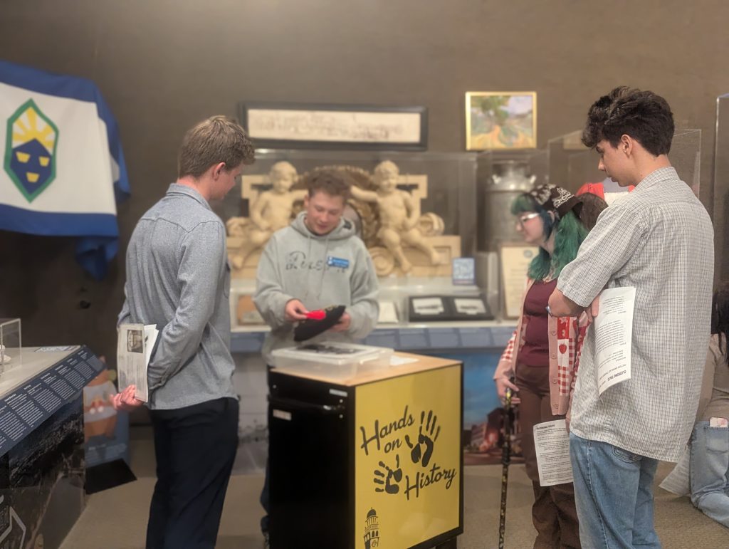 a group of interns and junior docents practice leading an activity in the COS@150 exhibit