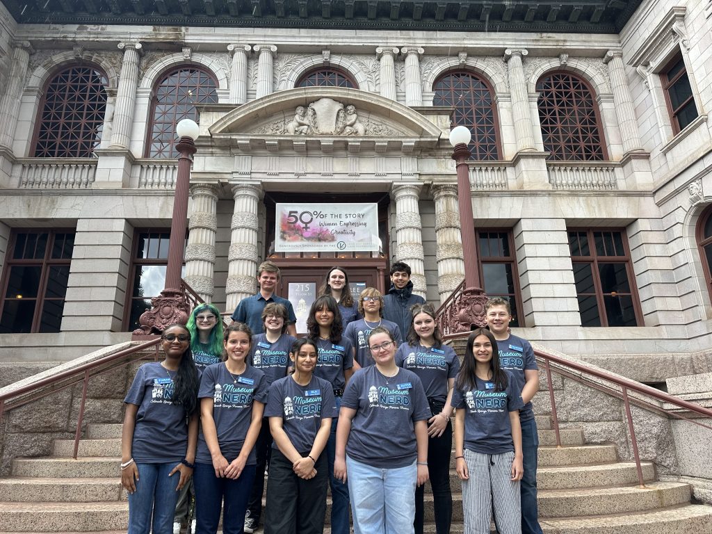 a group of teens and college students pose on the stairs in front of the Colorado Springs Pioneers Museim