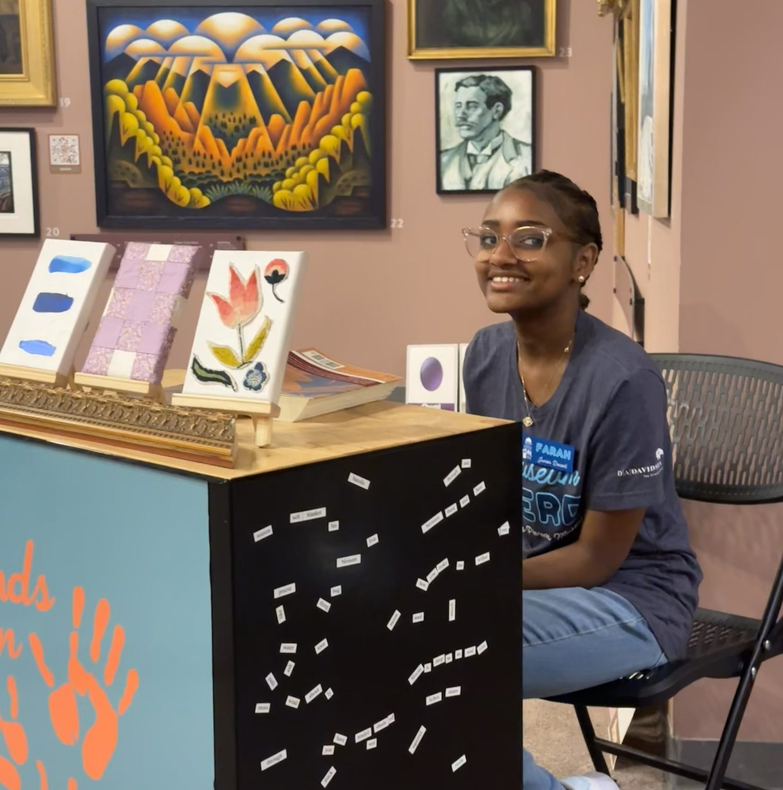 A teen volunteer works at an exhibit cart.