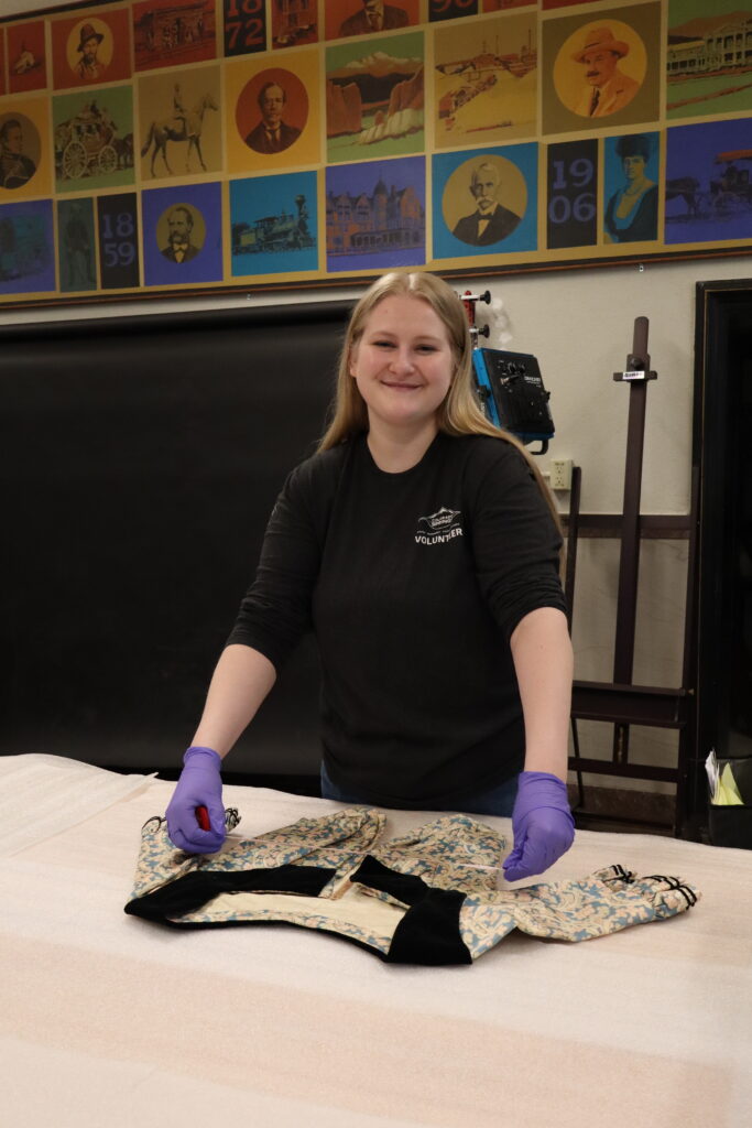 Volunteer Emma Rowe stands in the Museum's collections space.