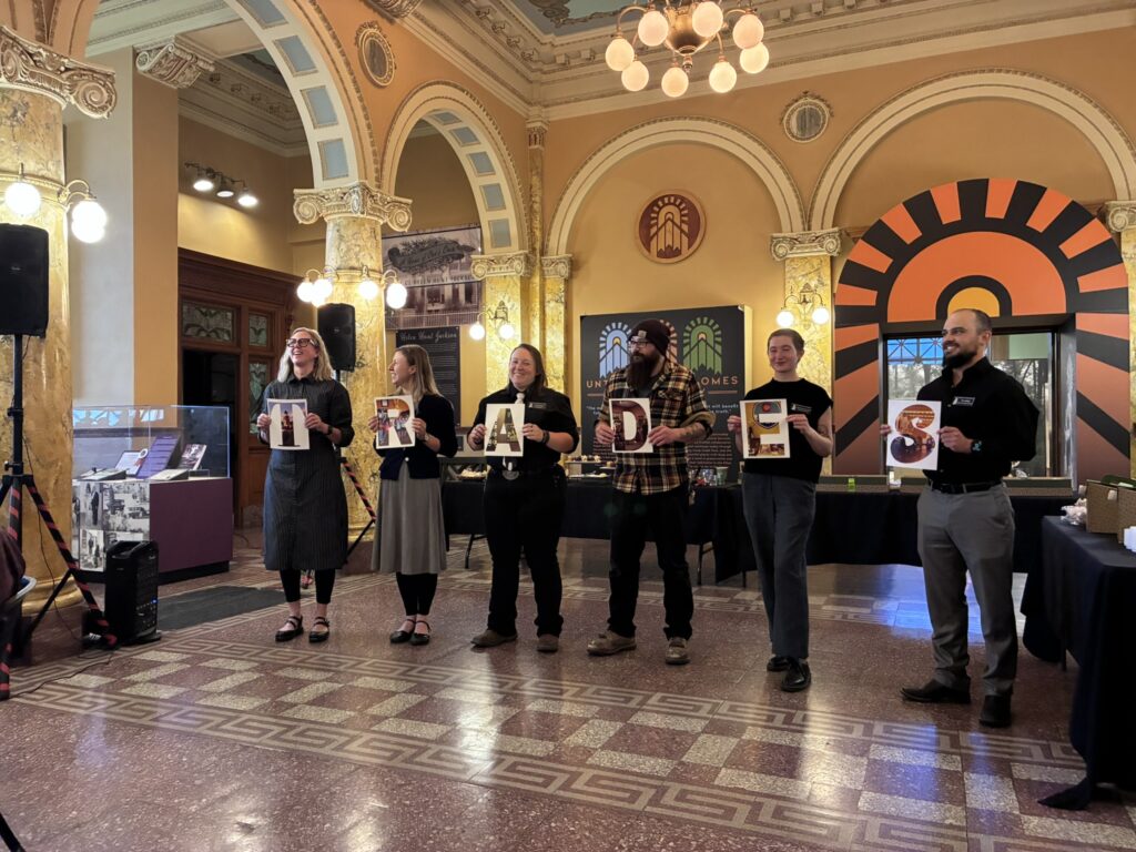 CSPM staff presenting the "TRADES" signage at the 2026 Volunteer Appreciation Breakfast