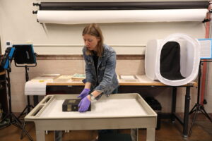 Hillary Mannion, CSPM Archivist, moves a copy of the 1935 Colorado Statutes Annotated to a table in the museum’s Collections Workspace.