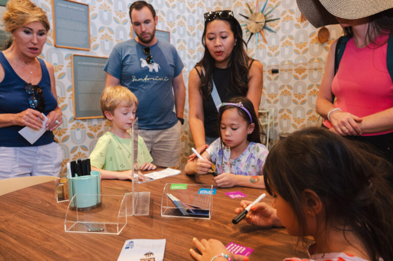 Visitors participating in a conversation activity at the "Freedom to Thrive" Kitchen Table.
